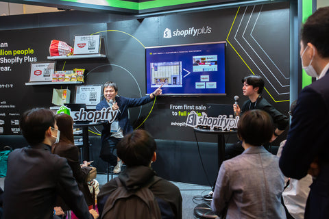 アドテック東京2022のShopifyブースで対談する株式会社はせがわ 藤山雅裕氏とShopify Japanの押切氏