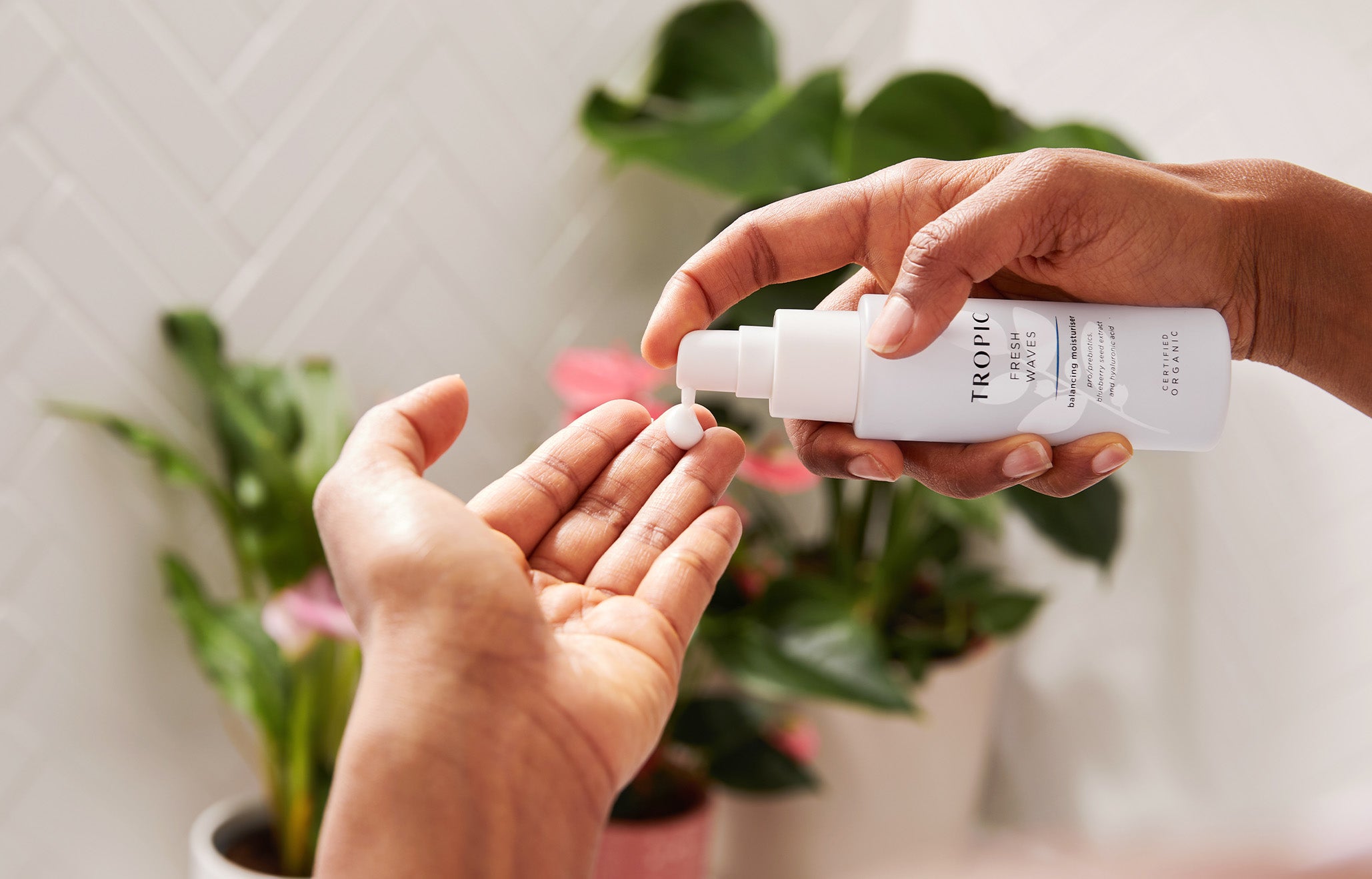 Women pumping fresh waves moisturiser into hand