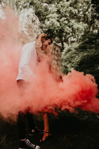 Couple With Pink Gender Reveal Smoke Around Them