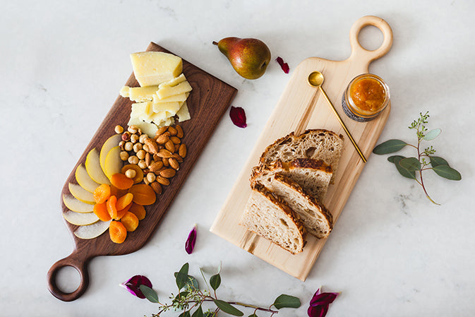 cutting boards with cheese and jam and fruit and nuts