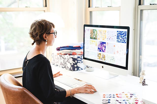 Artist in front of computer screen in office