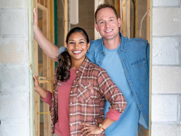 Brian and Mika Kleinschmidt pose in the doorway of an unfinished home. Courtesy of HGTV.