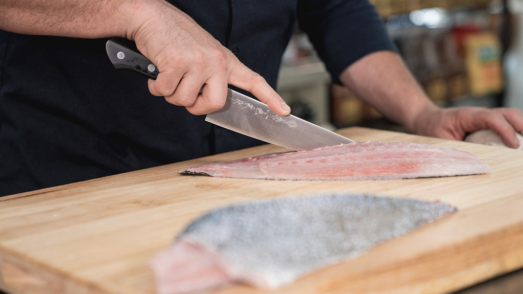 Chef Cutting Fish On Cutting Board