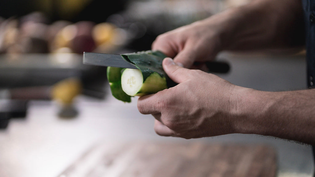 Home Chef cutting cucumber with a Nakiri