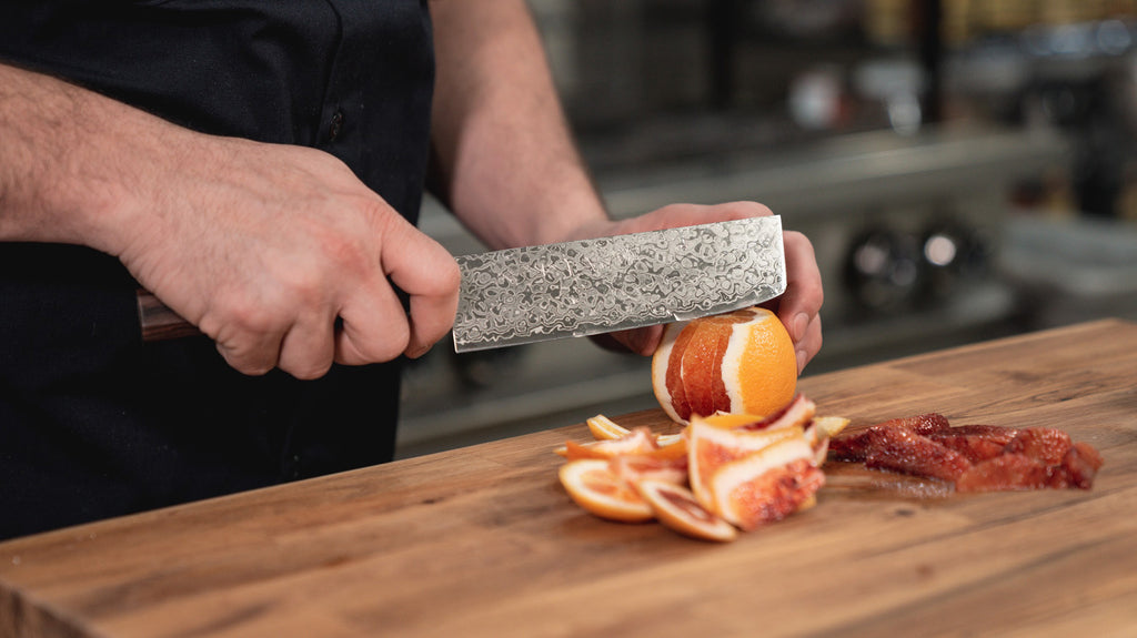 Home chef cutting oranges with a Nakiri