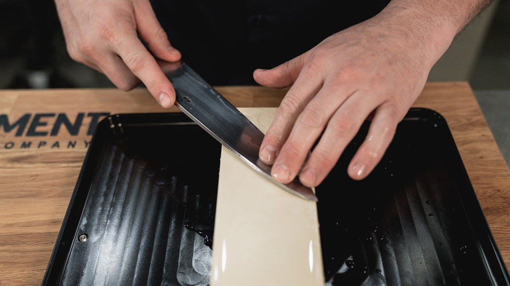 Sharpening a kitchen knife on a wet stone