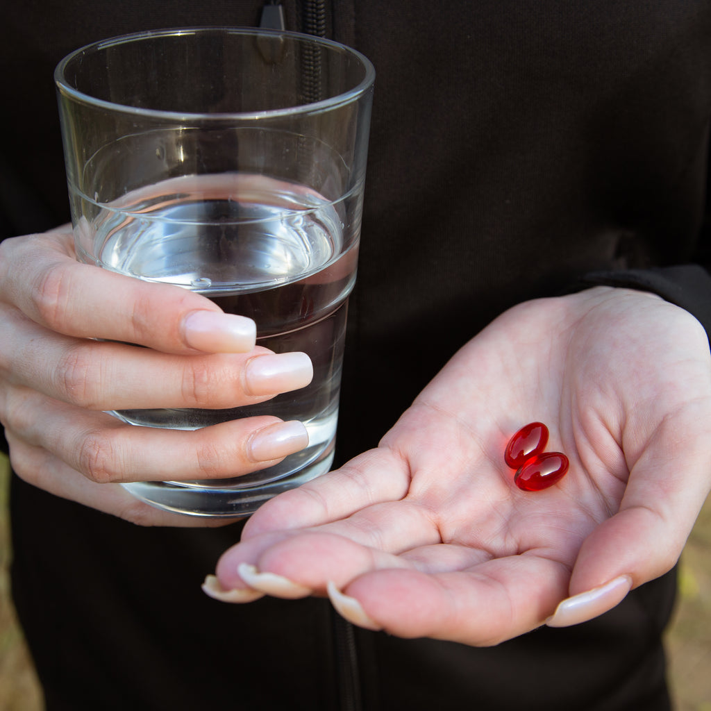 Red gel pills in hand