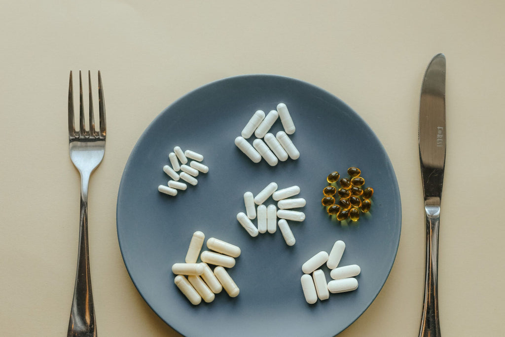 plate with pills on it and a fork and knife next to the plate