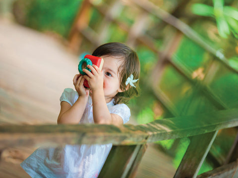 child playing outdoors with a pretend play camera