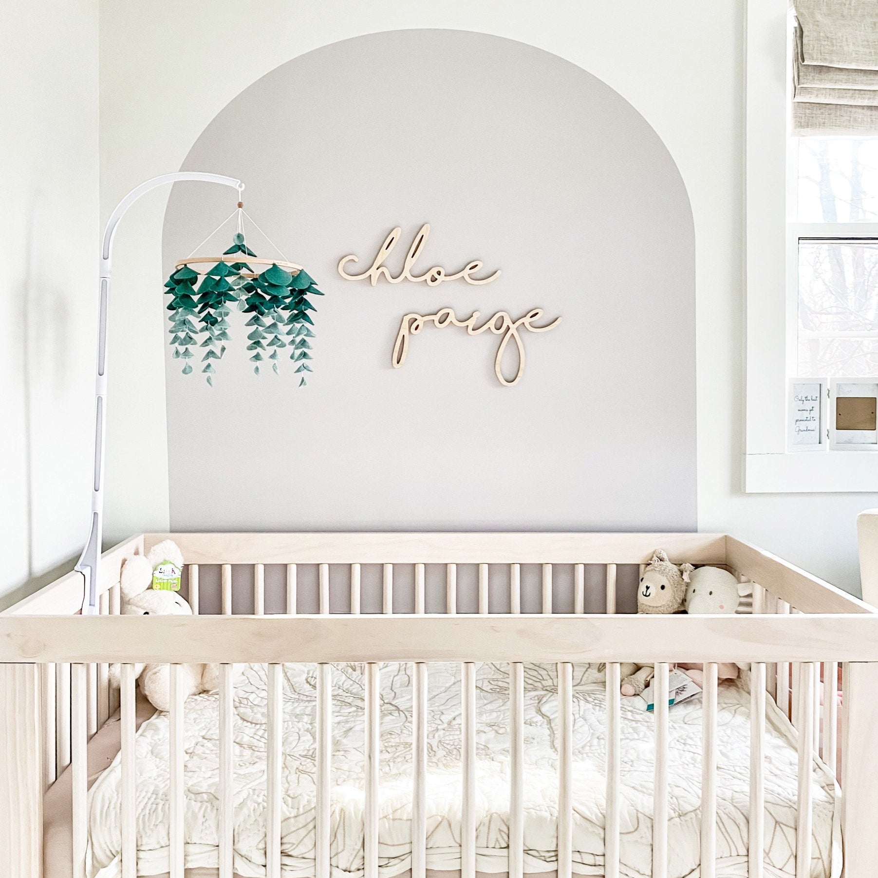 Baby Nursery with arch on accent wall with wooden name sign