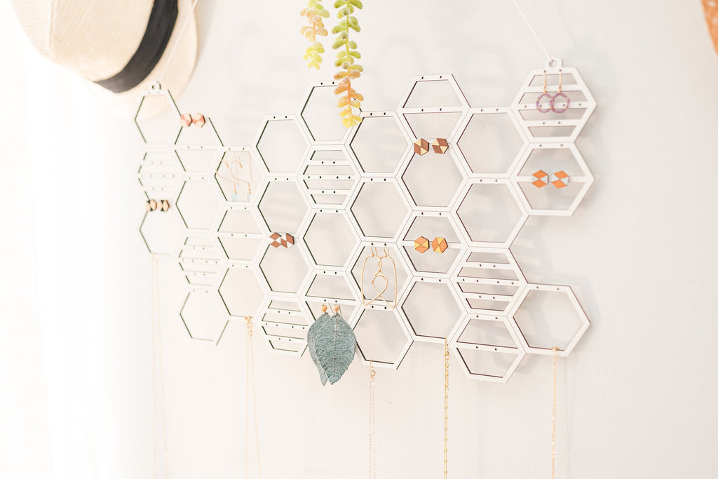 Honeycomb-shaped wall-mounted earring storage.