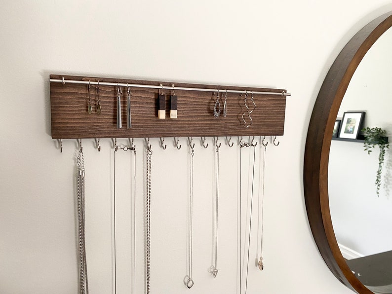 Wall-mounted jewellery organizer made of wood.