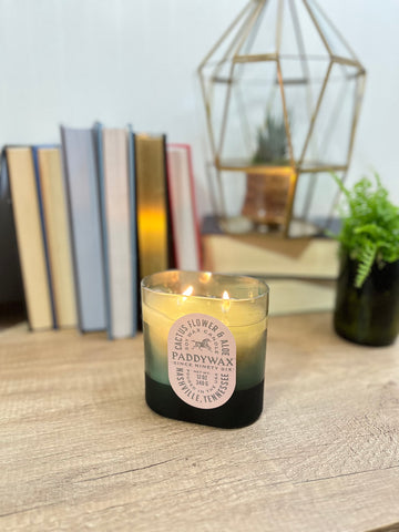 Vista Cactus Flower and Aloe candle in front of books on a table