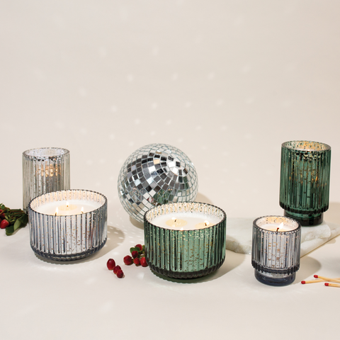 Silver and Green Mercury Glass Candles with disco ball and matches surrounding them on cream background