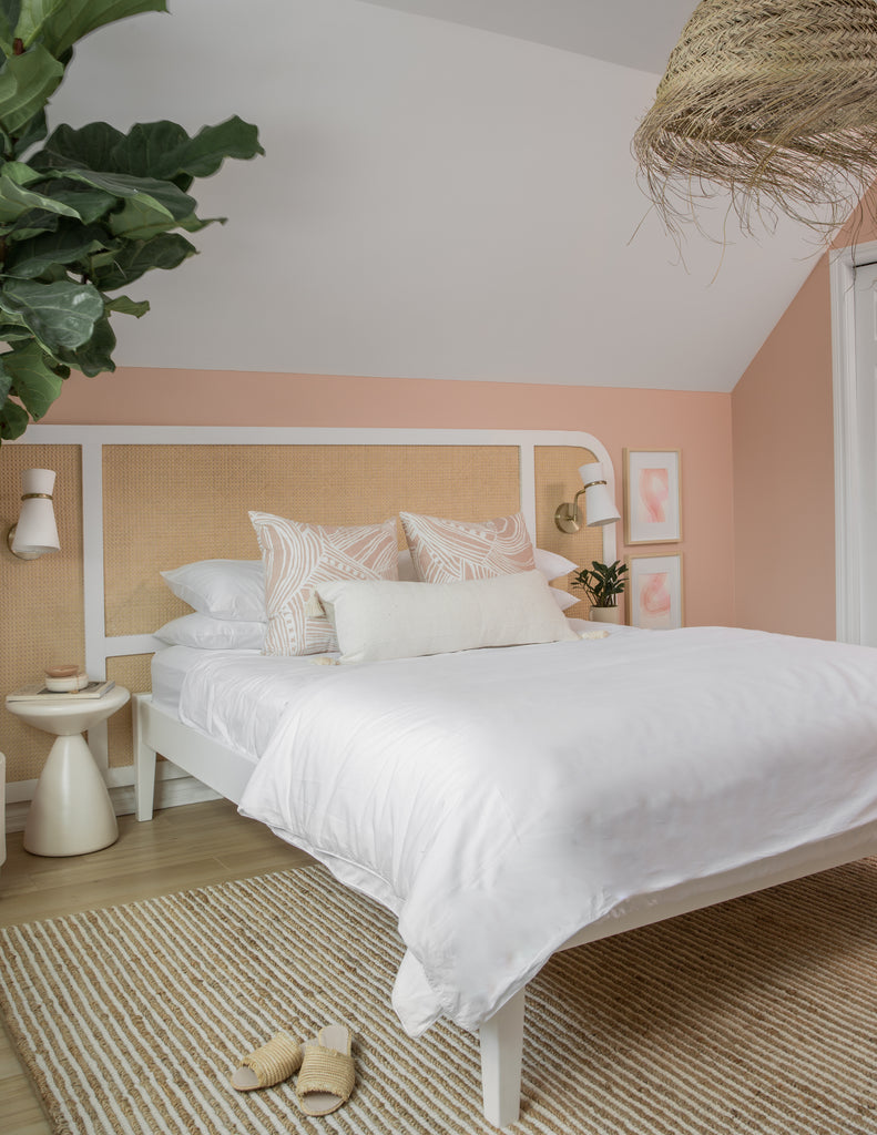 bedroom with pink wall, and white bedding