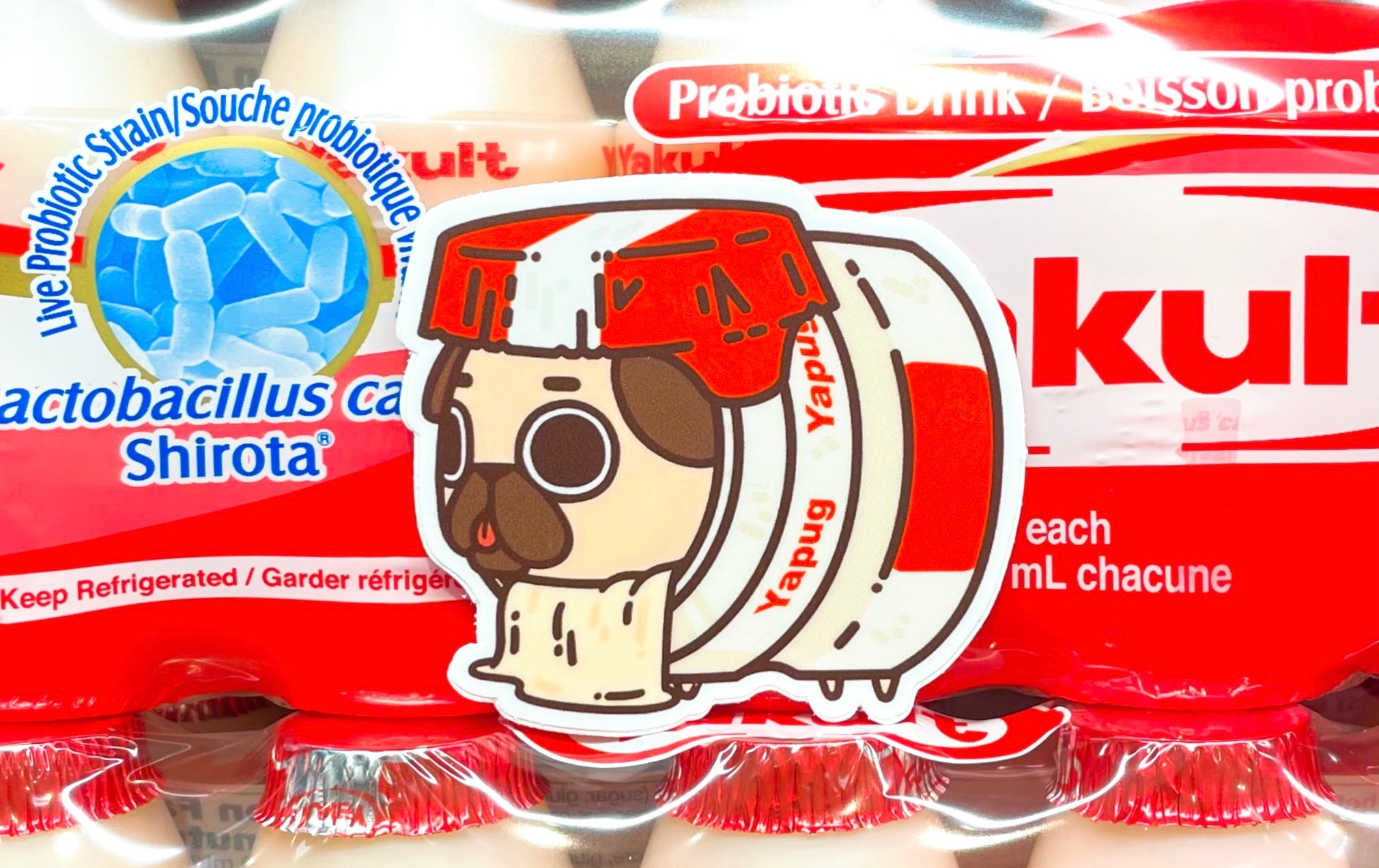Yakult Puglie sticker placed in front of a pack of Yakult.