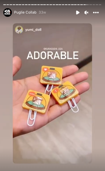 Instagram story showing a hand holding three Kura Sushi Puglie rubber bookmarks. Caption says, "Adorable!"