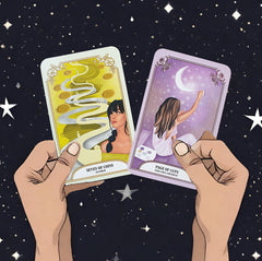 Two cards from the Crystal Magic Tarot deck (seven of coins and page of cups) held up by hands against a background of stars in the night sky
