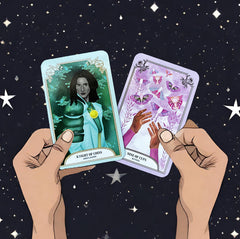 hands holding the knight of coins and Nine of cups cards from The Crystal Magic Tarot deck with a background of a starry night sky