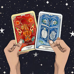 The hierophant and strength cards from he crystal magic tarot deck held up with two hands with a background of stars