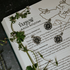 Yarrow  silver necklace, obol coin style with a green witch book background