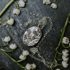 Lily of the valley flowers and a silver lily of the valley pendant