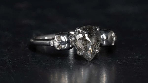 Salt and pepper diamond alternative engagement ring in silver with silver skulls