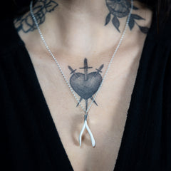 a three of swords tattoo and a wishbone necklace