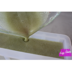 pouring hemp and pumice scrub bar mix into a silicone mold