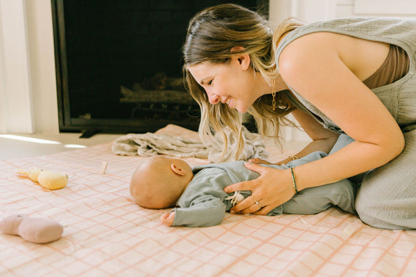 eli yonas, founder and owner of toki mats, playing with her baby on a toki mats play mat