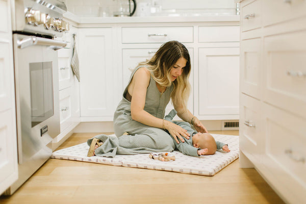toki mats founder eli yonas playing with her baby on a toki mats play mat