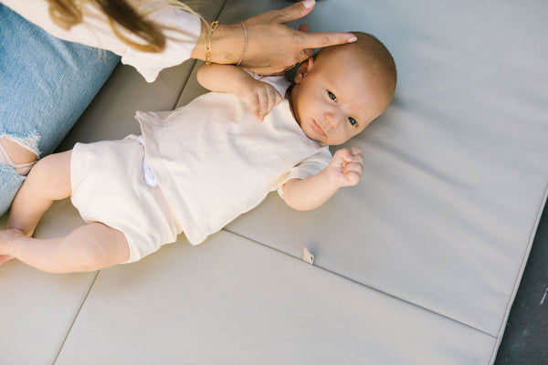 baby laying on toki mats play mat in pebble