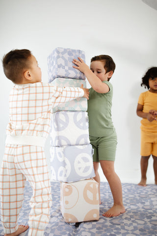 two children stacking toki play cubes vertically 
