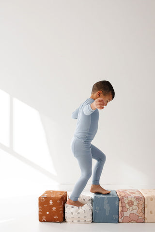 a child walking on top of toki play cubes