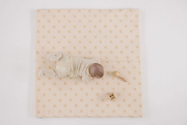 aerial view of a baby doing tummy time on a toki mats play mat