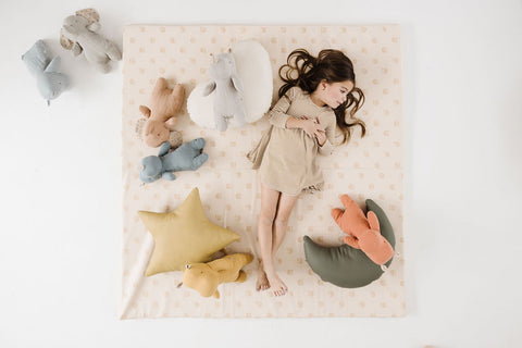 little girl laying on a toki mats play mat