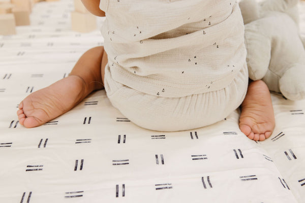 close up of baby sitting on a toki mats play mat