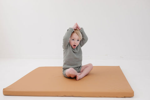 toddler sitting on a toki mats play cushion