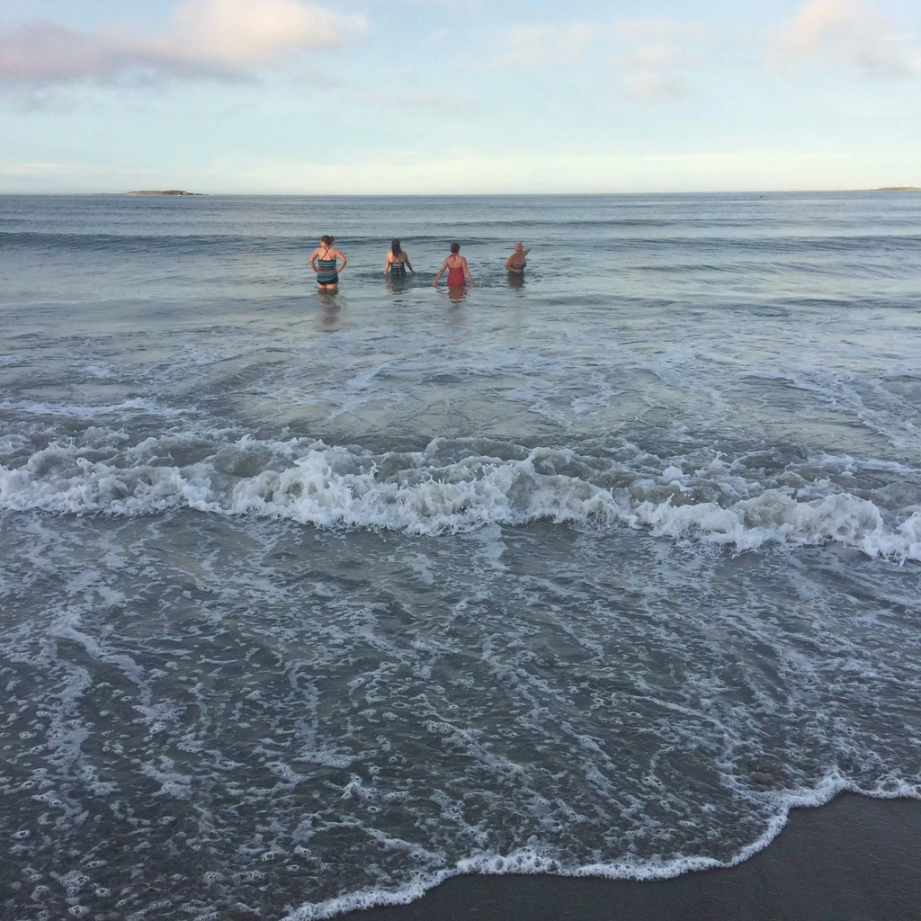 four figures out in the distance in the ocean 