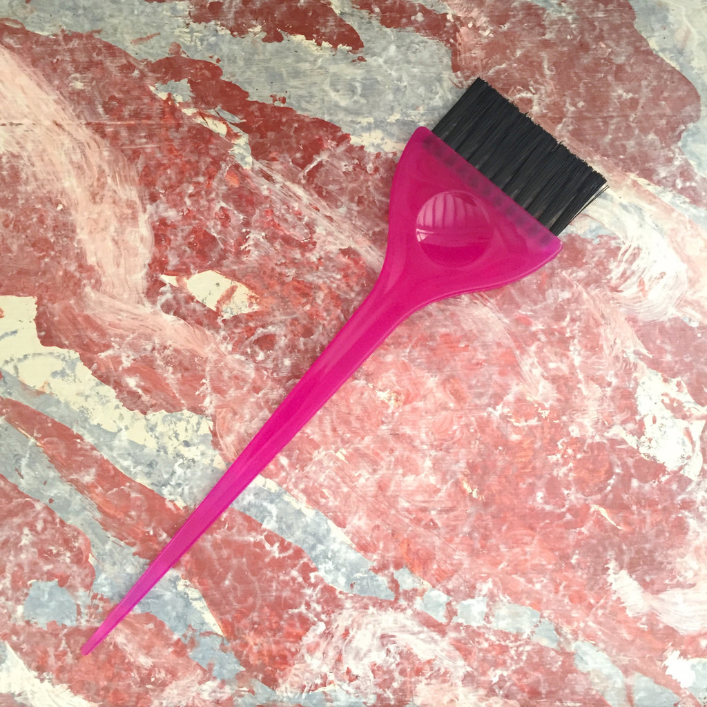 pink hair dye applicator brush on pink marble