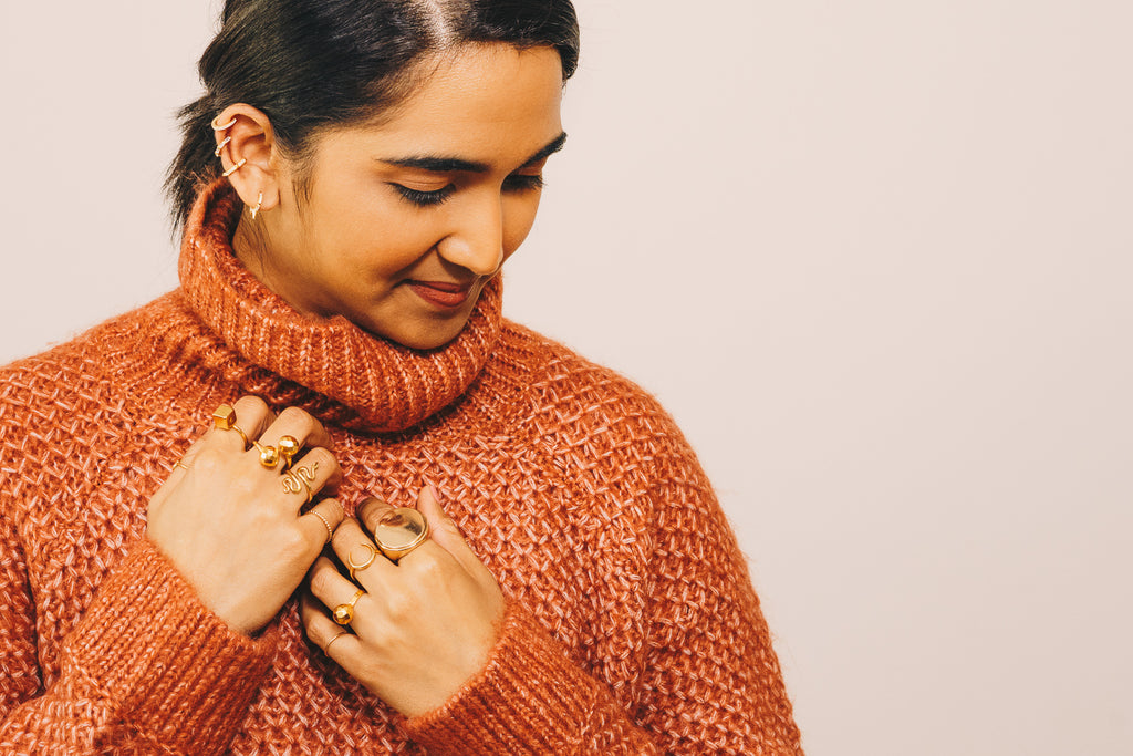 girl in orange turtleneck sweater with gold jewelry