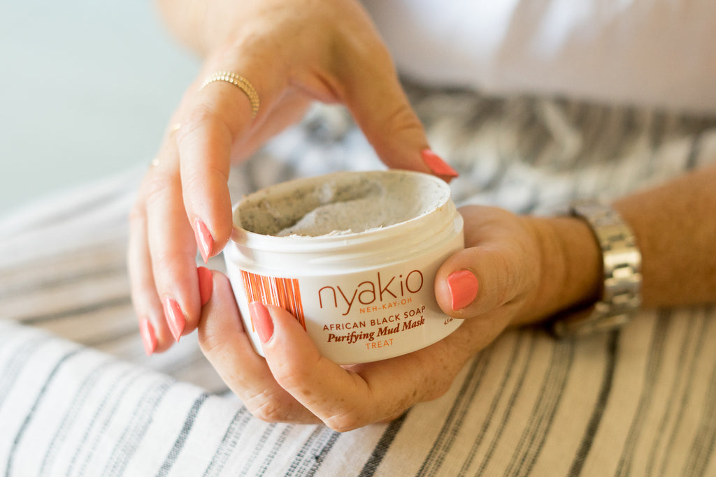 hands holding nyakio African black soap mud mask