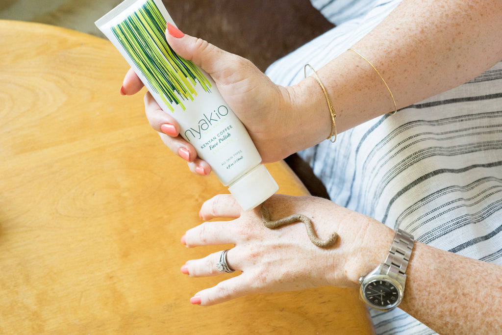 hands applying nyakio Kenyan coffee face scrub to hand