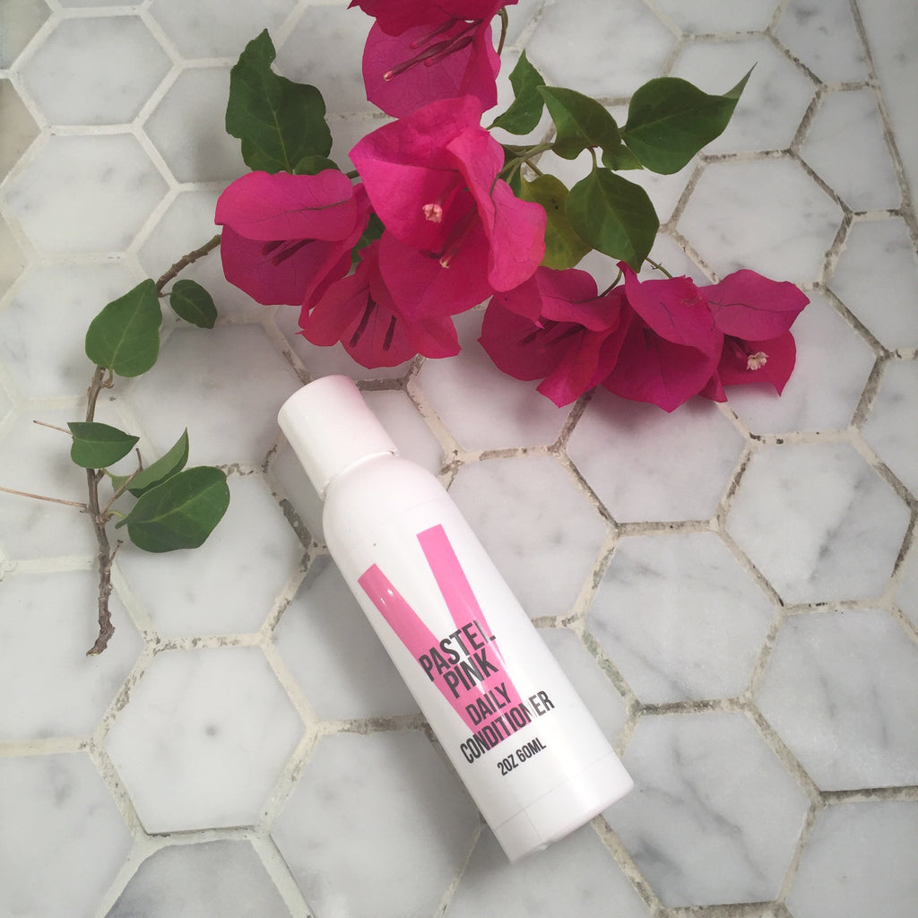 overtone pastel pink daily conditioner with bougainvillea on white tile floor