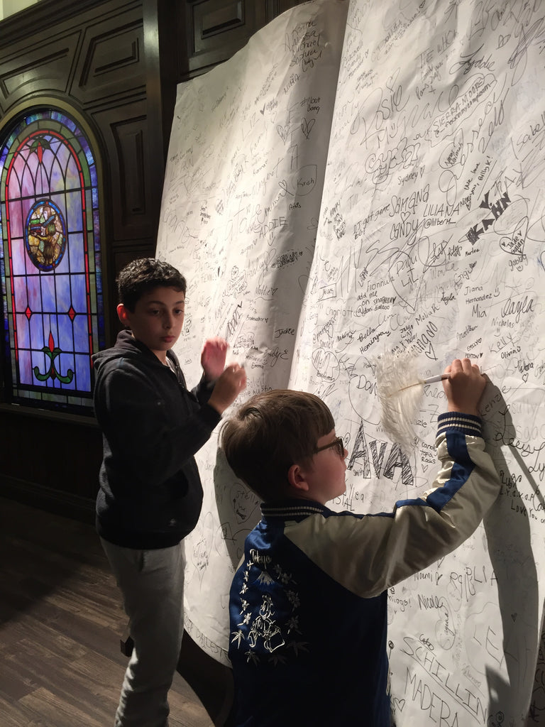 boys signing life-size giant book at candytopia