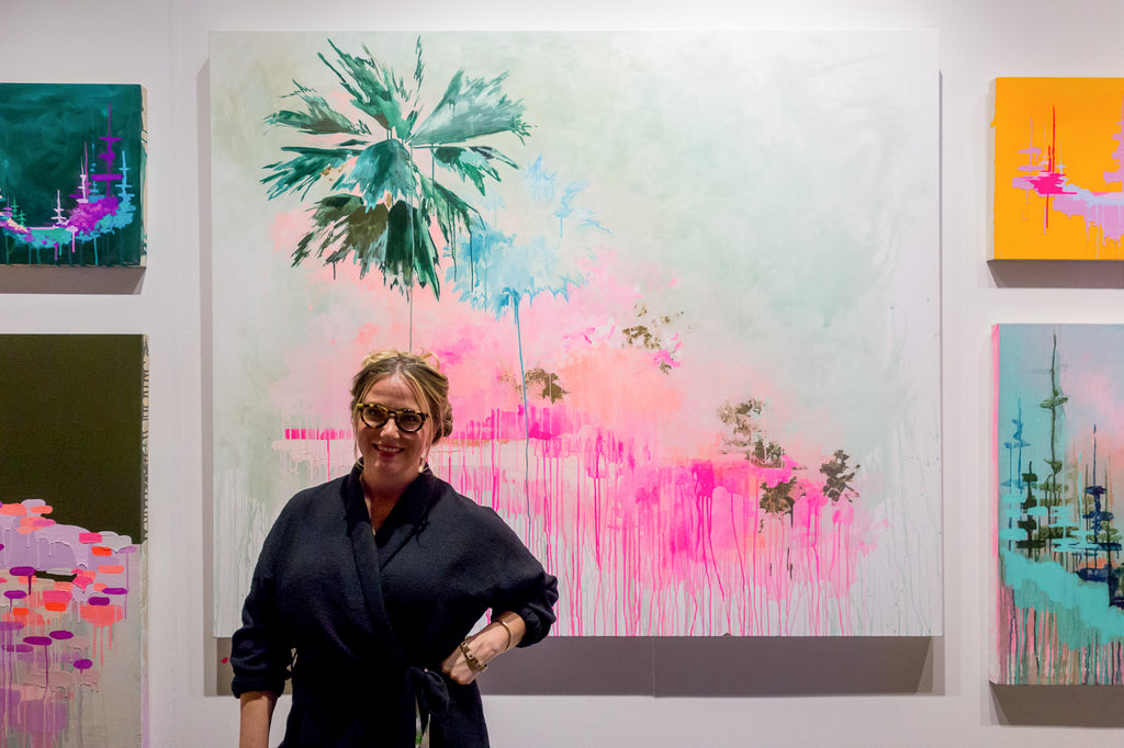 Kim West with neon palm tree painting at the Other Art Show the majestic Downtown LA