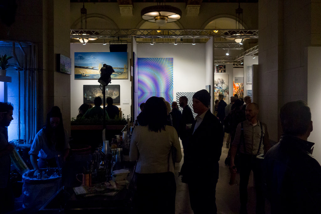 art in background with people in the dark foreground other art show at the majestic downtown la