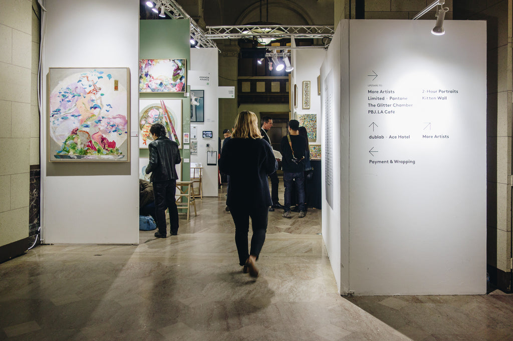 Janna Conner walking down aisle between art booths at the other art show majestic downtown la