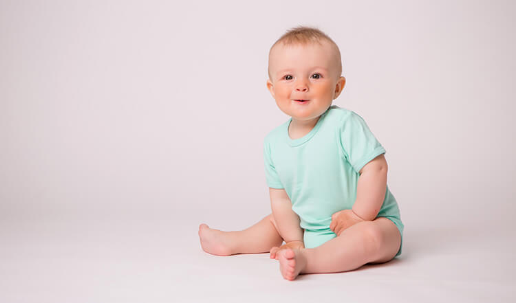 baby wearing green onesie