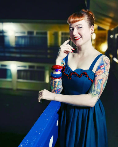 Stef Jay Pinup-Model trägt Splendette Vintage-inspirierte Fakelite-Armreifen in Rot und Blaugrün